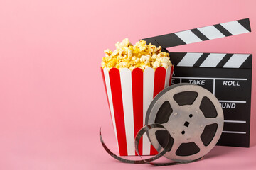 Tasty popcorn in buckets and cold cola drinks with cinema tickets, movie clapper and 3D eyeglasses...