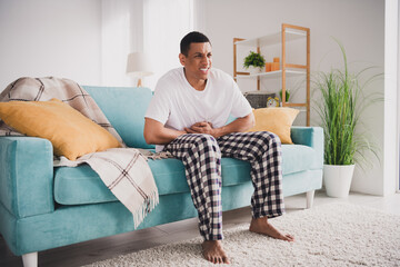 Photo of unhealthy upset guy sleepwear pajama feeling stomachache staying home sofa indoors house...