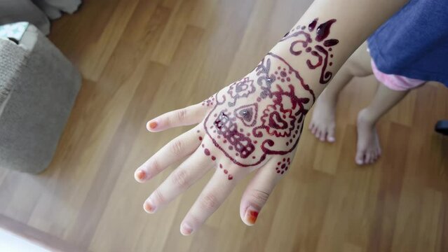 Top view of henna drawn on a little girl's hand at home. 4K Handhel