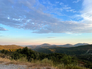 Beautiful blue sky with clouds over mountains and greenery