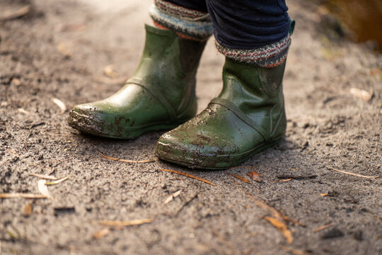 muddy boots of gumboots and wellies on a walk with mud and water in winter