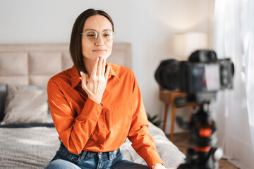 Positive caucasian woman talking and showing sign language while recording video