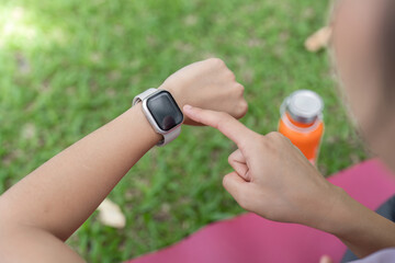 Young Healthy Woman Exercising Outdoors with Smartwatch, Staying Fit and Active in Nature