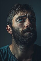 Fototapeta premium Man looking up with worried expression in low light