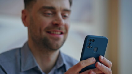 Cheerful employee hands typing message on mobile phone at workplace closeup