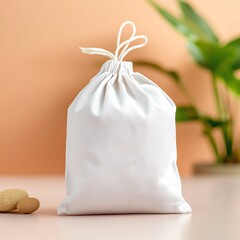 White cotton drawstring bag isolated on pink background.