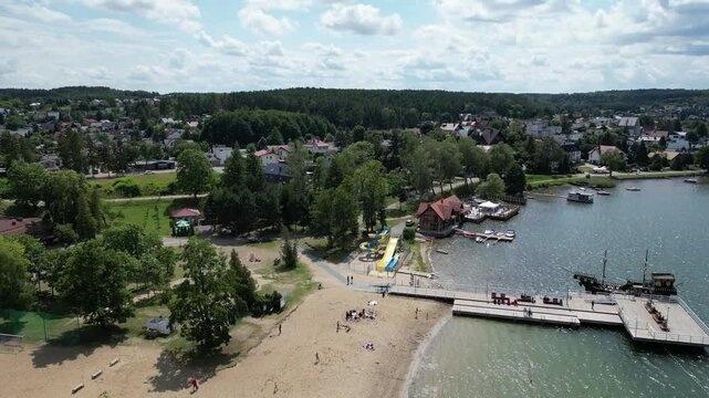 picturesque village aerial upwards lake beach harbor vessels boats docked tourism holiday travel vacation destination