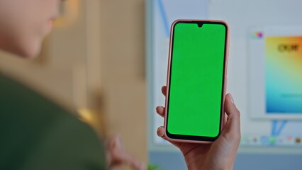 Businesswoman scrolling greenscreen smartphone at office workplace close up.