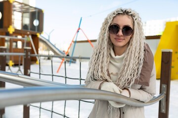 Woman With White Hair and Sunglasses at Playground
