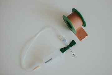 butterfly needle for drawing blood and medical tape for a medical worker with a white background