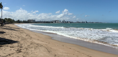 puerto rico beach (luquillo waterfront with sand and mountains) tropical island vacation getaway (waves crashing on shoreline) paradise