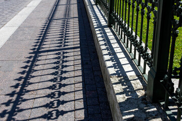 Pattern from shaped contrasting shadow from vintage fence.