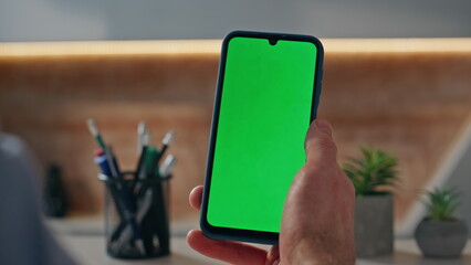 Guy hands holding mockup cellphone at office workplace closeup. Man browsing