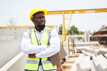 African black male worker crossed arms and looking at camera at construction site.