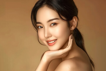 Fototapeta premium Portrait of a young Asian woman smiling with a natural beauty, light makeup, glowing skin, and elegant hairstyle, set against a beige background. 