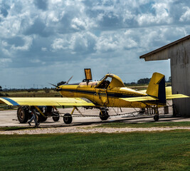 A yellow propeller crop duster being serviced