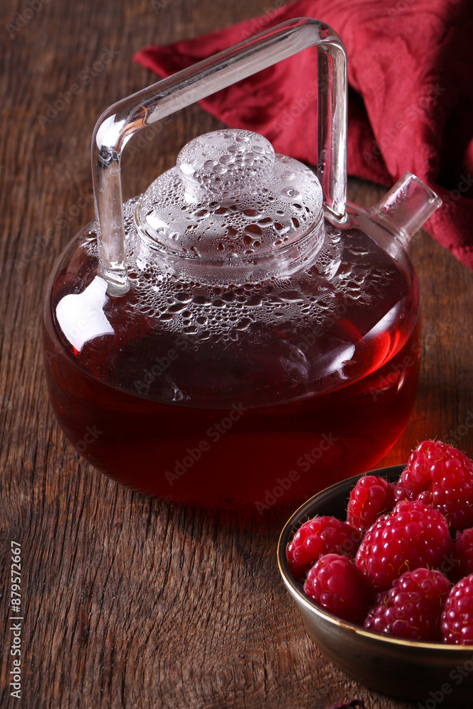 Poster berry raspberry tea in a teapot on a wooden table