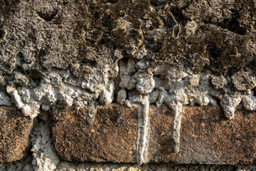 at close range. Old bricks or walls with black moss and melted cement casts in neglected buildings. Building wallpaper background concept