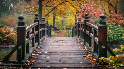 Obraz premium A bridge with a wooden deck and a path leading to it. The bridge is surrounded by trees and has a lot of leaves on it. The leaves are falling from the trees, creating a beautiful and serene atmosphere