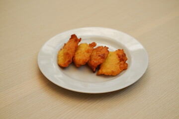 Corn croquettes on a white plate on a wooden table