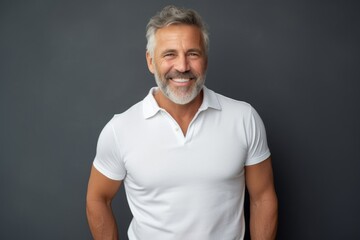 Portrait of a joyful man in his 50s donning a classy polo shirt isolated on minimalist or empty room background