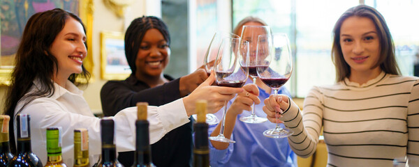 Diverse people are testing wine and talking together in the restaurant.