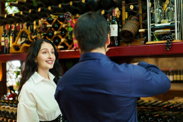 Diverse people testing wine together inside the wine cellar.