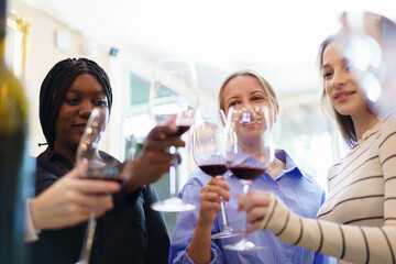 Diverse people are testing wine and talking together in the restaurant.