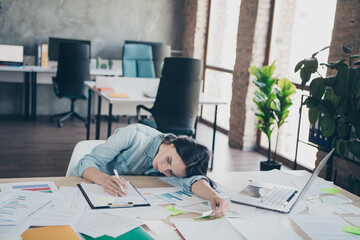 Photo of attractive young woman lying tired table dressed denim clothes executive business leader...