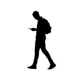 Silhouette of a man walking while using a smartphone