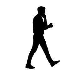 Silhouette of a man walking while using a cellphone