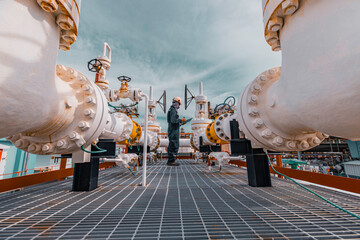 Male worker inspection at steel long pipes and pipe elbow in station oil factory during refinery...
