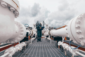 Male worker inspection at steel long pipes and pipe elbow in station oil factory during refinery...