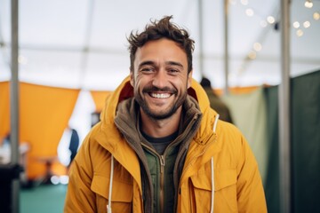 Naklejka premium Portrait of a happy man in his 30s wearing a warm parka over solid color backdrop
