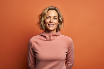 Obraz premium Portrait of a satisfied woman in her 40s wearing a thermal fleece pullover on solid color backdrop