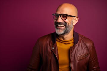 Obraz premium Portrait of a happy man in his 40s sporting a stylish varsity jacket isolated in solid color backdrop