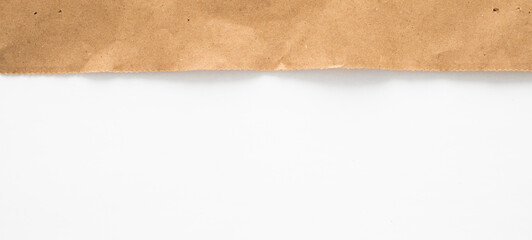 A piece of brown paper is torn across the top of the image, revealing a white background.