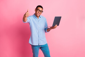 Photo of cheerful positive guy dressed checkered shirt working modern device showing thumb up...