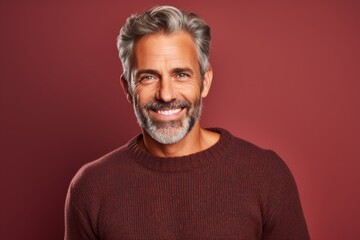 Obraz premium Portrait of a blissful man in his 50s wearing a cozy sweater isolated in solid color backdrop