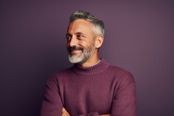 Obraz premium Portrait of a blissful man in his 50s wearing a cozy sweater over solid color backdrop