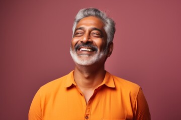 Obraz premium Portrait of a satisfied indian man in his 60s donning a trendy cropped top on solid color backdrop