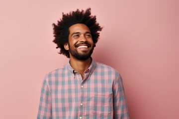 Obraz premium Portrait of a jovial afro-american man in his 30s dressed in a relaxed flannel shirt over solid pastel color wall
