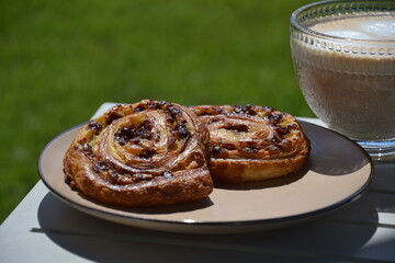 Glass cup of coffee  and  puff pastry outdoor on table in shade