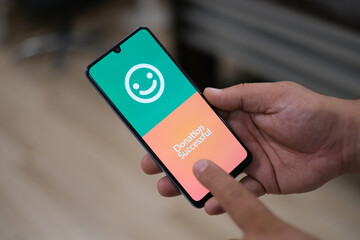 'Donation Successful' message on smartphone screen. Close-up donation campaign message. 