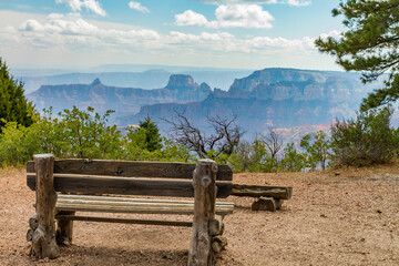 A bench on the north rim of the Grand Canyon with a panoramic view.