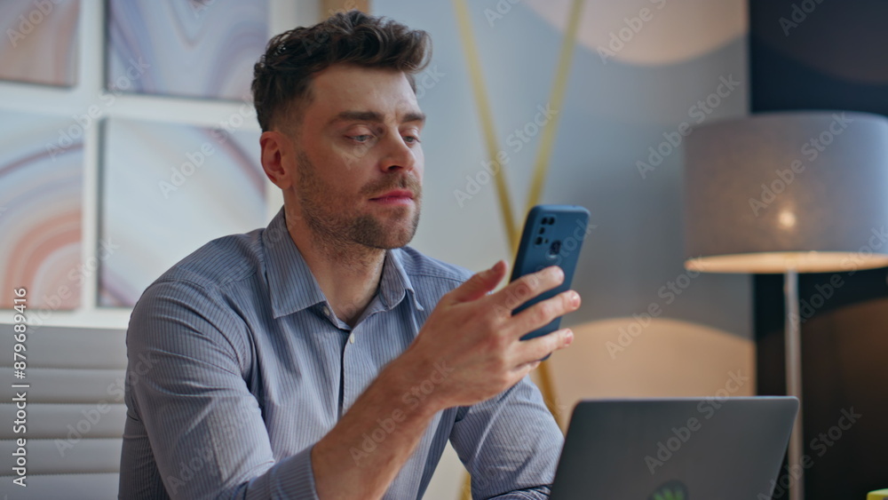 Poster relaxed man scrolling smartphone feed enjoying break at private cabinet closeup