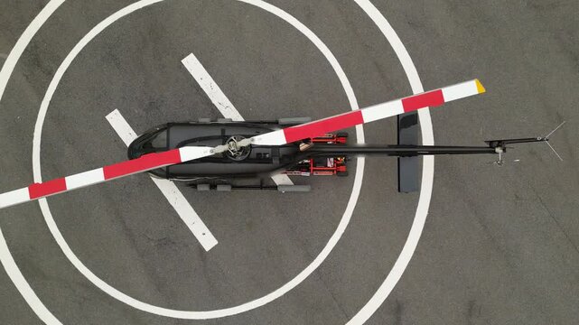 helicopter parked on helipad with remote controlled pushback cart driving underneath black modern 