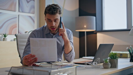 Angry businessman talking smartphone in office closeup. Nervous man call phone