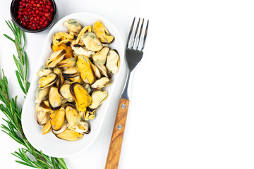Mussels on a plate with a fork and seasonings, top view, space for text