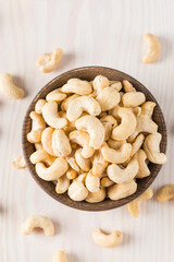 Organic roasted cashew nuts in a wooden bowl. Top view. 